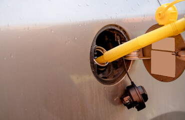 A man filling the fuel tank of his car with diesel fuel from the jerry can as there is no fuel at...