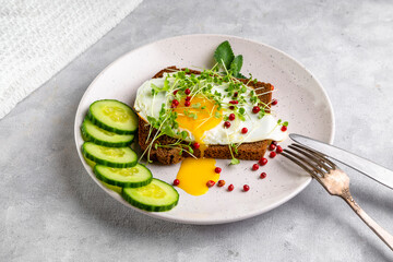 Sandwich with scrambled eggs, microgreens and pink pepper on a plate. Delicious and healthy snack