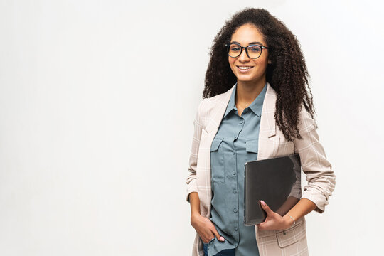 Young African American Woman With Afro Hairstyle Wearing Smart Casual Wear And Stylish Eyeglasses Standing Isolated On White , Carrying Laptop Computer, Smiling, Female Office Employee, Student