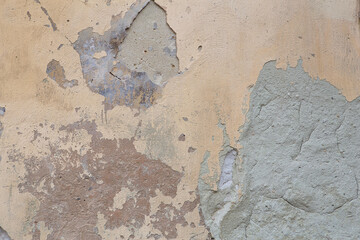 Old flaky wall with destroyed plaster. Renovation of old house. Industrial style design wall background. Grunge cracked concrete wall with old paint. Shabby peeling old background