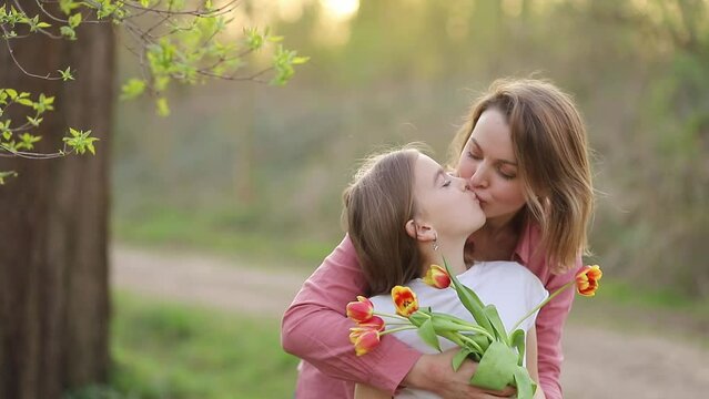 mother hugs and kisses daughter. mothers Day