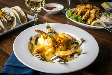 Funky Striped Cheese Ravioli with Shrimp in a Cream Sauce on a Wooden Table