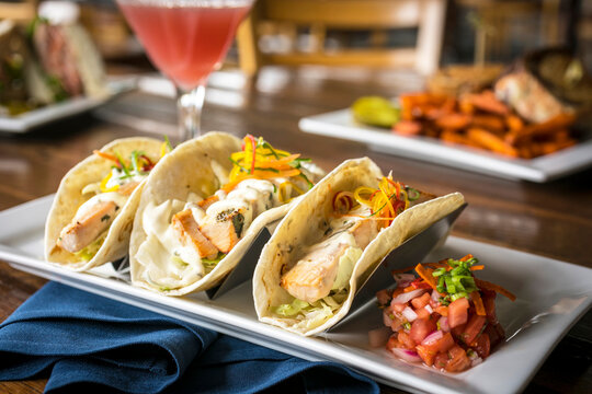 Close Up of 3 Fish Tacos on a Wooden Table