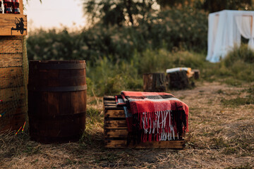 In the village in nature in the grass there is a wooden barrel and wooden boxes