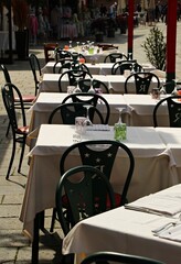 Italy, Veneto:Tables and chairs in the restaurant in the sun.