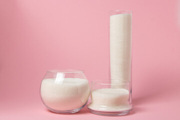 Sugar on a pink background. Sugar in different glass vessels. Sugar reserves