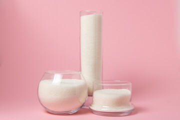 Sugar on a pink background. Sugar in different glass vessels. Sugar reserves