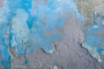 Old flaky wall with destroyed plaster. Renovation of old house. Industrial style design wall background. Grunge cracked concrete wall with old paint. Shabby peeling old background