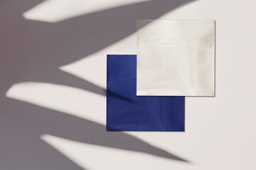 two brown business cards with plants shadows.