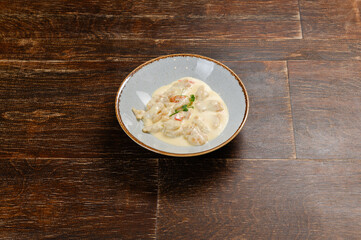 shrimps cooked in creamy sauce on a wooden background