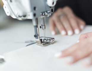 female hands at work with sewing machine
