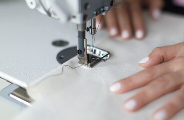 female hands at work with sewing machine