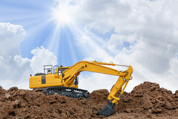 Excavator with Bucket lift up are digging  soil in the construction site on cloud and sunbeam  background