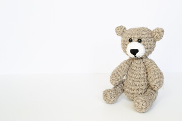 Crochet gray bear on white background. Crocheted bear