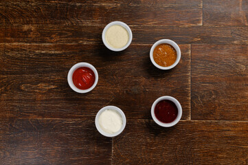 Obraz na płótnie Canvas five sauces for every taste on a wooden background