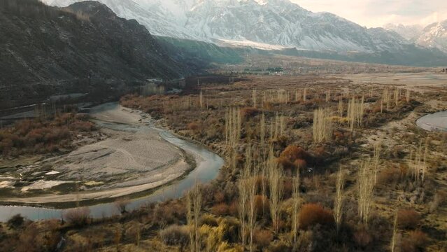 Aerial Flying Over Sweeping Landscape Of Ghizer Valley Of Gilgit Baltistan With Snow Capped Mountains In The Distance. Dolly Forward, Establishing Shot