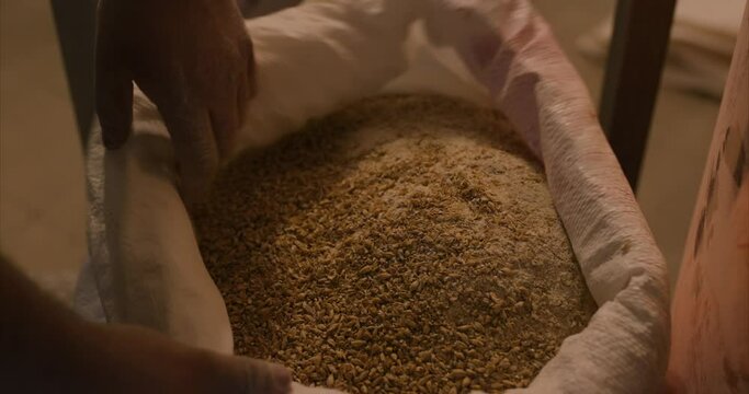 ground malt in a bag ready for brewing beer in a brewery handheld shot slow mo