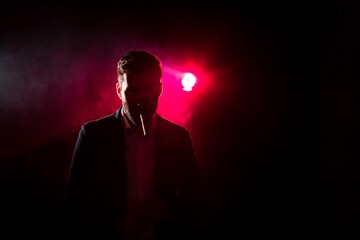 Photo of man smoking on pink background.