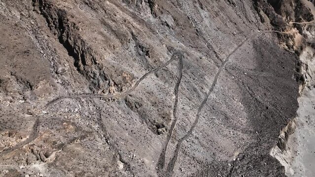Aerial View Of Winding Old Silk Road Through Rugged Arid Mountains In Pakistan. Dolly Back Rising