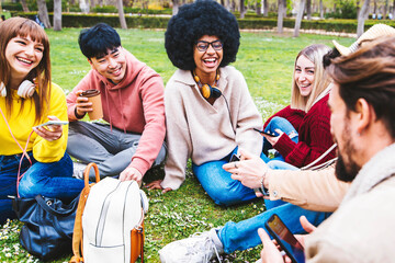 Group of multiracial students sitting in college campus - Young people having fun talking and...