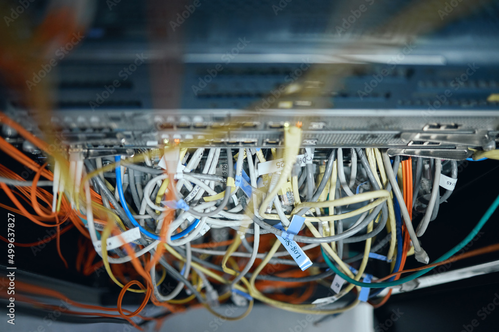 Poster in need of some cable management. high angle shot of cables inside of a server room.
