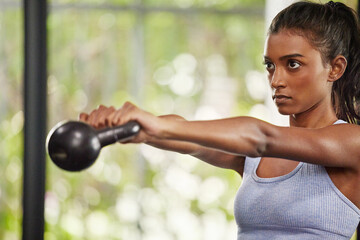 Keep doing it until you see results. Shot of a young woman working out with a kettle bell at the...