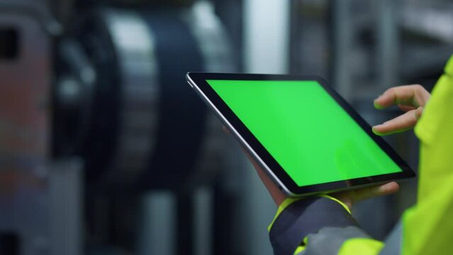 Hands Scrolling Greenscreen Tablet Computer On Modern Production Factory.