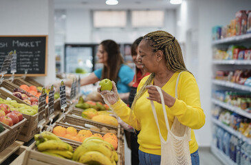 African senior woman buying fresh organic fruits inside local mini market