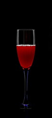 A glass of young wine on a black background.