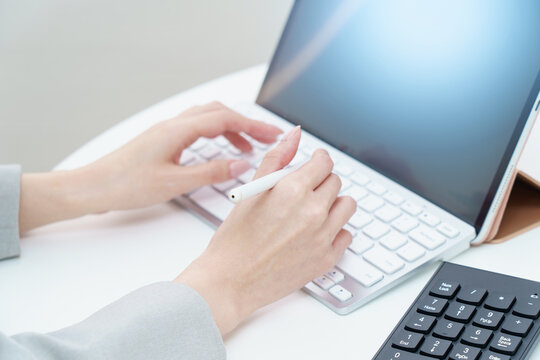 パソコンのキーボードを打つ女性の手元