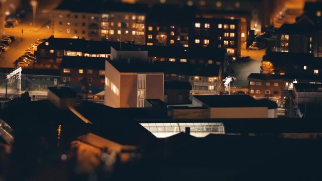 A train passes the station in the town of Narvik at night. Timelapse tilt-shift video.