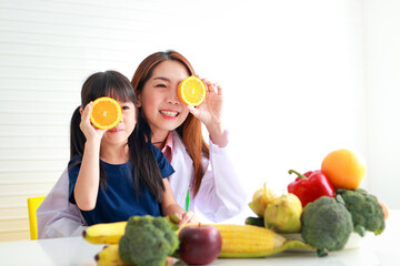 Nutrition for school-age children. A beautiful nutritionist or doctor with a little girl holding an...