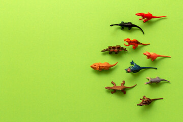 Top view toy dinosaurs on green background