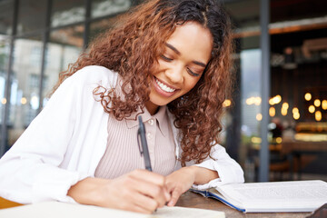 The life of a student. Shot of a young businesswoman writing in a notebook while at a cafe.