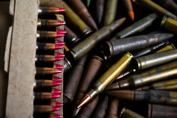 Pile and box of bullets which are new and old on dark background, soft and selective focus.