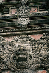 Demon face stone carving at Tirta Empul Temple, Bali, Indonesia