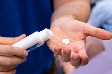 Close up man hand applies magnesium on his hand before training in the gym.