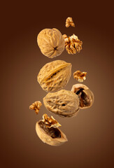walnuts fly on brown background, selective focus