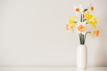 Mixed daffodils in a white simple bud vase