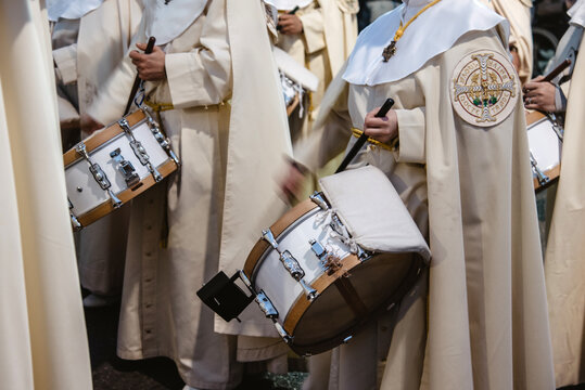 Miembro de la banda de música de la cofradía de La Sagrada Cena de Valladolid, España, tocando el tambor durante una procesión de Semana Santa. 