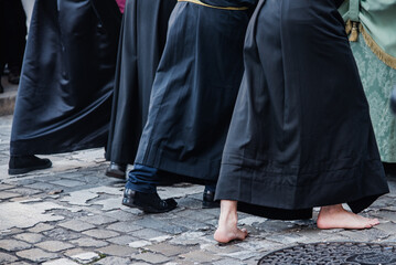 Detalle de un cofrade descalzos empujando un paso de Semana Santa en España. Cofradía de la...