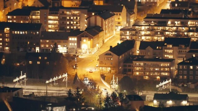 Nighttime timelapse of the Narvik city in northern Norway. Cars rush through the brightly lit streets.