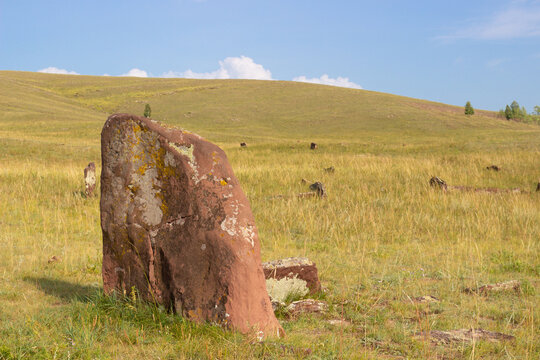 Ancient menhirs and mounds located in the steppe in Khakassia. A menhir standing stone, orthostat, or lith is a large man-made upright stone, typically dating from the European middle Bronze Age.