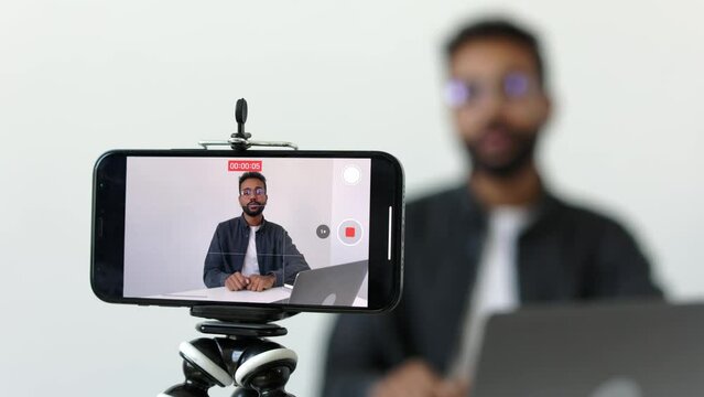 Close up shot focused on phone camera with handsome young african ethnicity male applicant in glasses holding video call job interview with hr manager. Happy mixed race man answering questions.