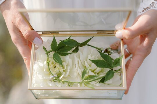 Bride holding a box with flowers and wedding rings