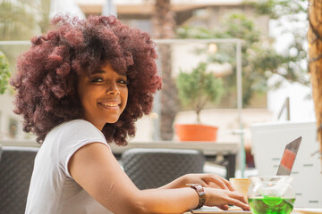 Young Afro woman in a coffee shop working online