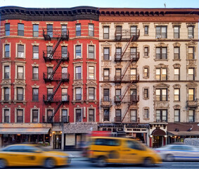 Fototapeta na wymiar Old apartment buildings on 2nd Avenue in the East Village neighborhood of New York City with taxis driving down the street
