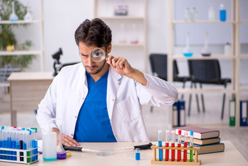 Young male chemist working at the lab