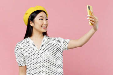 Young smiling happy woman of Asian ethnicity 20s wear white polka dot t-shirt yellow beret doing...