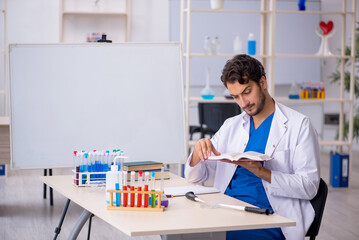 Young male chemist working at the lab